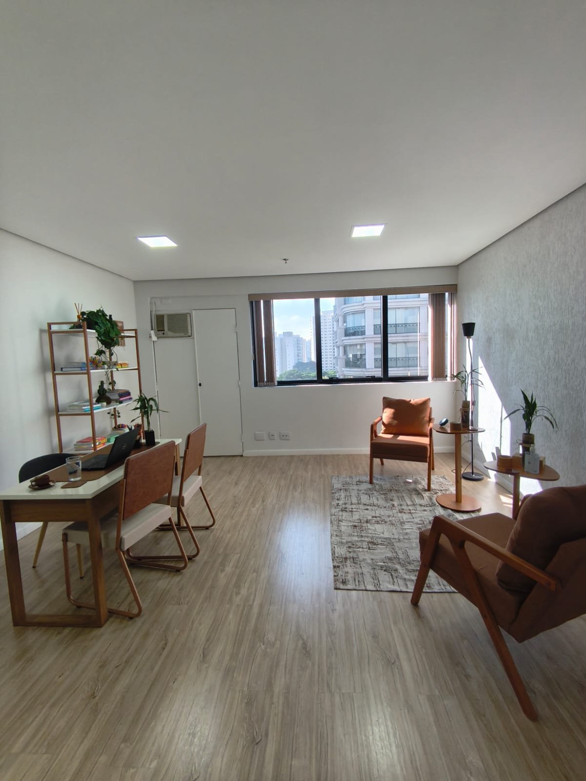 Vista geral do consultório com poltronas e janela com luz natural